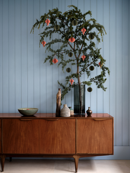 tannenzweige in vase mit schmuck blaue wand FarrowandBall decohome.de